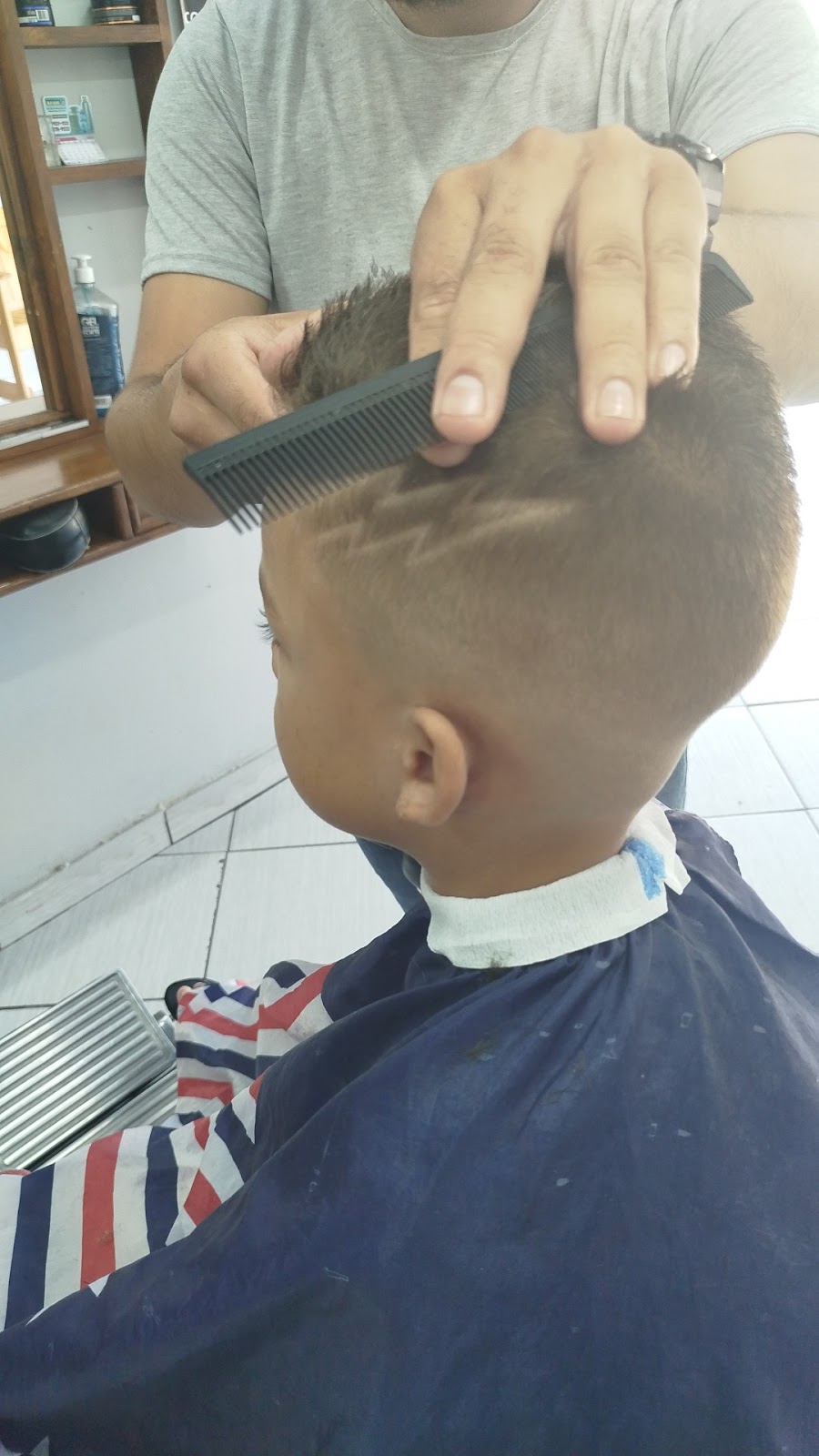 Criança sendo atendida na Barbearia Guih Santos