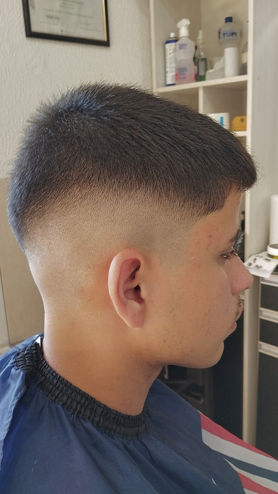 Detalhe do pente e da tesoura durante um corte na Barbearia Guih Santos